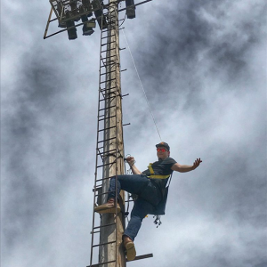 Individual up on lighting pole ladder