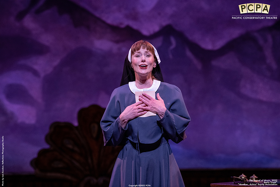 Actor playing Maria singing onstage in Sound of Music