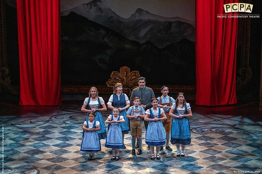 Actors as the von Trapp family singing on stage in Sound of Musice